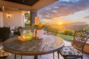 克尼斯納的住宿－Pezula Magic Retreat - 4 Bedroom Home with Inverter，露台上的一张桌子,享有日落美景