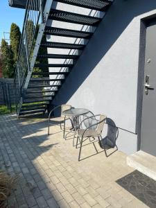 a table and chairs on a patio with a staircase at Niezapominajek in Opole +4 photos