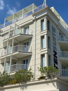 a white building with a hotel sign on it at Residence Ten Suite in Rimini
