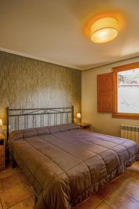 sypialnia z dużym łóżkiem i oknem w obiekcie Barranco de la Olla by Apartamentos Arnedillo w mieście Arnedillo