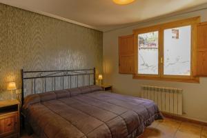 sypialnia z łóżkiem i oknem w obiekcie Barranco de la Olla by Apartamentos Arnedillo w mieście Arnedillo