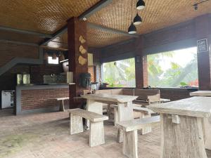 a restaurant with wooden tables and benches in a room at Panji Hostel in Sukasada