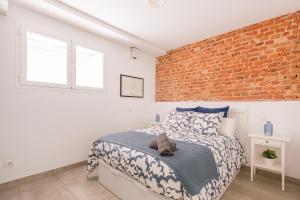 um quarto com uma cama e uma parede de tijolos em Duplex in the center of Madrid (B2) em Madri