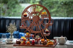 a table with a wheel with cupcakes and food on it at Oriental Residence Bangkok in Bangkok