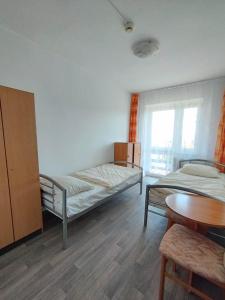 a room with two beds and a table in it at Koralowa Ścieżka in Jagniątków