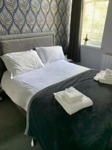 a bed with two white towels on top of it at Riverside in Musselburgh
