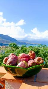 un bol vert de nourriture assis sur une table dans l'établissement La finestra sul mare, à Castellammare del Golfo