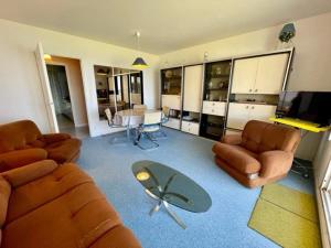 ein Wohnzimmer mit einem Sofa, Stühlen und einem Tisch in der Unterkunft Appartement Quiberon, 3 pièces, 4 personnes - FR-1-478-242 in Quiberon