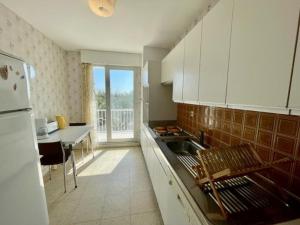 eine Küche mit einer Spüle, einem Tisch und einem Kühlschrank in der Unterkunft Appartement Quiberon, 3 pièces, 4 personnes - FR-1-478-242 in Quiberon