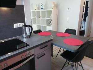 eine Küche mit einem Tisch mit roten Platten darauf in der Unterkunft Fewo Seelöwe Haffkrug in Haffkrug