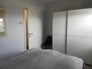 ein Schlafzimmer mit einem Bett und einem großen weißen Schrank in der Unterkunft Fewo Seelöwe Haffkrug in Haffkrug