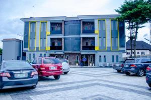 un estacionamiento con autos estacionados frente a un edificio en Moratel Hotels, en Port Harcourt