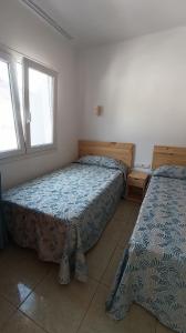 um quarto com 2 camas e uma janela em Apartamentos Boomerang I em Tamaduste