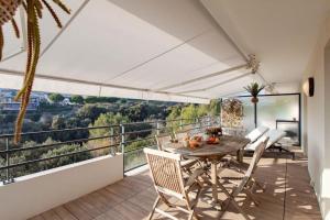 een patio met een tafel en stoelen op een balkon bij L8 Calm, panoramic Sea View withTerrace, Parking & AC in Saint-Laurent-du-Var