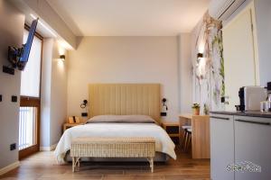 a bedroom with a large bed and a kitchen at GuerriniBNB Civico 5 in Manerbio