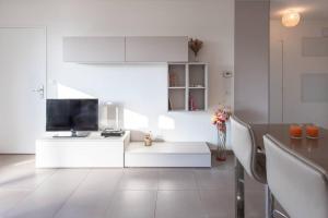 een witte woonkamer met een televisie en een tafel bij L8 Calm, panoramic Sea View withTerrace, Parking & AC in Saint-Laurent-du-Var