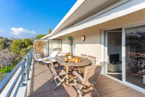 een patio met een tafel en stoelen op een balkon bij L8 Calm, panoramic Sea View withTerrace, Parking & AC in Saint-Laurent-du-Var