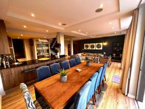 a large wooden table with blue chairs around it at One On Houghton in Cape Town