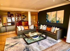 a living room with two couches and a table at One On Houghton in Cape Town