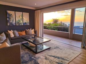 sala de estar con sofá y vistas al océano en One On Houghton, en Ciudad del Cabo