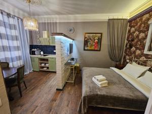 a bedroom with a bed and a desk and a kitchen at Studios on Grigore Vieru in Chişinău