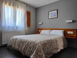 Un dormitorio con una cama grande y una ventana en Hotel Puerta de Javalambre en La Puebla de Valverde