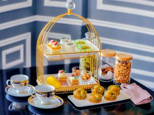 a tray of pastries and cups on a table at Hotel Del Luna Boutique in Da Nang