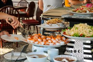a buffet with plates of food on a table at Hotel Del Luna Boutique in Da Nang
