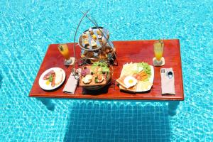 uma bandeja de comida numa mesa ao lado de uma piscina em Hotel Del Luna Boutique em Da Nang