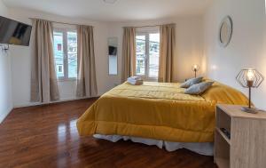 a bedroom with a large bed with a yellow bedspread at Happy Guest Apart 50 in Ushuaia