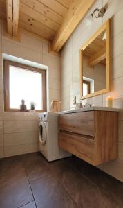 a bathroom with a washing machine and a sink at Domki inNatura in Istebna