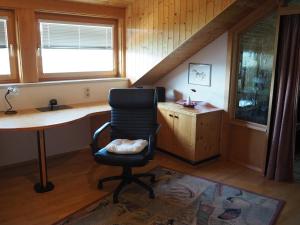 ein Büro mit einem Schreibtisch und einem Stuhl in einem Zimmer in der Unterkunft Haus Herberg Millstatt in Millstatt