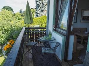 einen Balkon mit 2 Stühlen, einem Tisch und einem Fenster in der Unterkunft Haus Herberg Millstatt in Millstatt