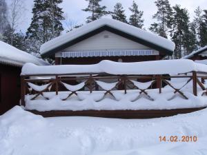 a house covered in snow with a fence at Föllingen stugan in Kisa