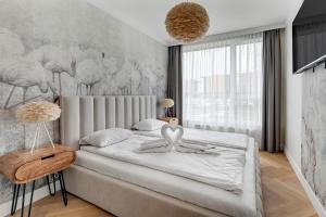 sypialnia z dużym łóżkiem i dużym oknem w obiekcie RentPlanet - Apartamenty Chlebova w Gdańsku