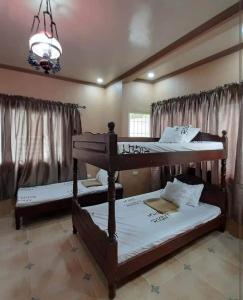 1 dormitorio con 2 literas y lámpara de araña en Shawn's Transient House at New Clark City en Calingcuan