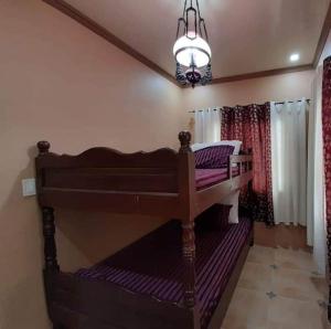 Cama en habitación con lámpara de araña en Shawn's Transient House at New Clark City en Calingcuan