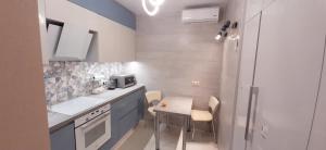 cocina pequeña con mesa pequeña y sillas en FlatService Затишні та просторі апартаменти в ЖК Parklend en Kiev