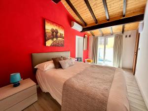 a bedroom with a red wall with a bed and a window at Hotel Alla Fontanella in Alassio