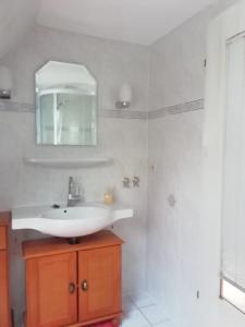 a white bathroom with a sink and a mirror at Ferienwohnung Loewe in Plau am See