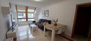 a living room with a blue couch and a table at Miramar in Viveiro