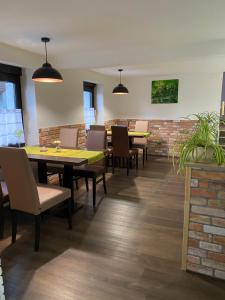 a dining room with tables and chairs and a brick wall at Hotel Unter den Linden in Kierspe