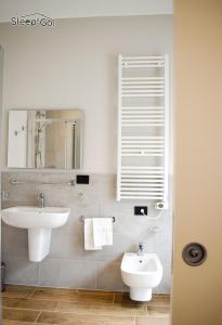 a bathroom with a sink and a toilet and a mirror at GuerriniBNB Civico 5 in Manerbio