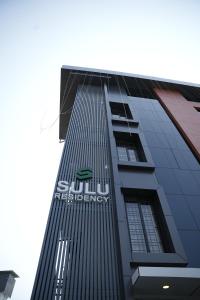 um edifício alto com o logótipo de energia sudirman nele em Sulu Residency em Ernakulam