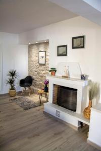 a living room with a fireplace and a chair at MariMar in Balíon