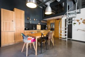 a kitchen with a wooden table and some chairs at Le Gambrinus - Loft Rochelais in La Rochelle