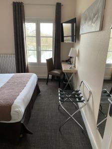 a hotel room with a bed and a desk at Hostellerie de Pavillon Saint-Hubert in Gouvieux