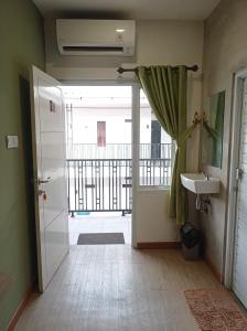 een badkamer met een deur naar een balkon bij RUMAH KOPI SYARIAH HOTEL in Bandar Lampung