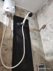 una ducha con una manguera pegada a la pared en Citadel Inn en Manila