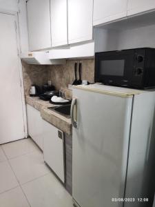 a kitchen with a refrigerator and a microwave at Citadel Inn in Manila